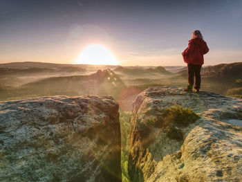 Woman with outdoor clothes enjoying view at summit top in mountains. traveling lifestyle concept