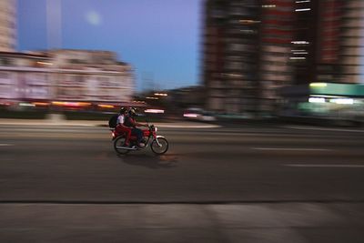 Blurred motion of man riding motorcycle on road