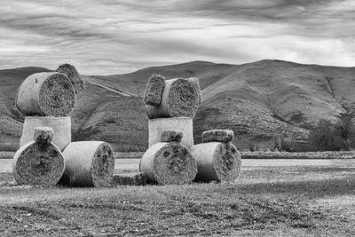 Hay bales on field against sky