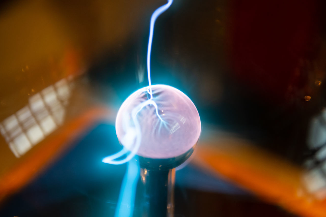 CLOSE-UP OF LIGHT BULB AGAINST ILLUMINATED LIGHTS