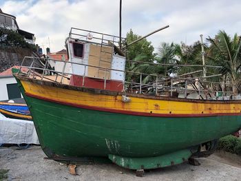 Boat moored at shore against sky