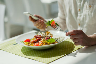 Midsection of man having food in plate