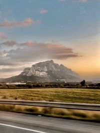 Road by snowcapped mountains against sky during sunset