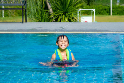 Portrait of young woman swimming in pool