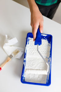 Cropped hand of person cleaning equipment on table