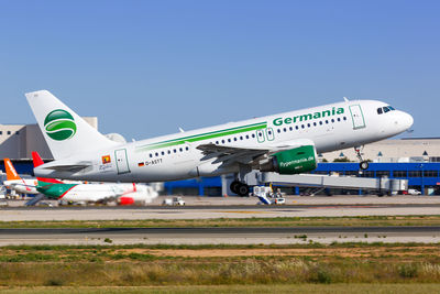 Airplane on airport runway against clear blue sky