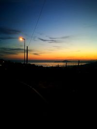 Silhouette road against sky during sunset