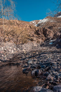 Rock formation in river against sky