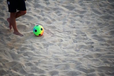 Low section of person playing with ball on beach