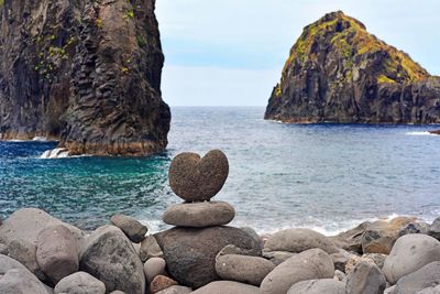 Rocks on sea shore against sky