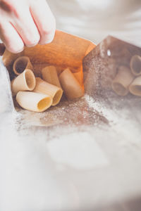 Cropped image of hand packing pasta in factory