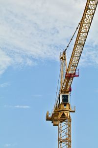 Low angle view of crane against sky