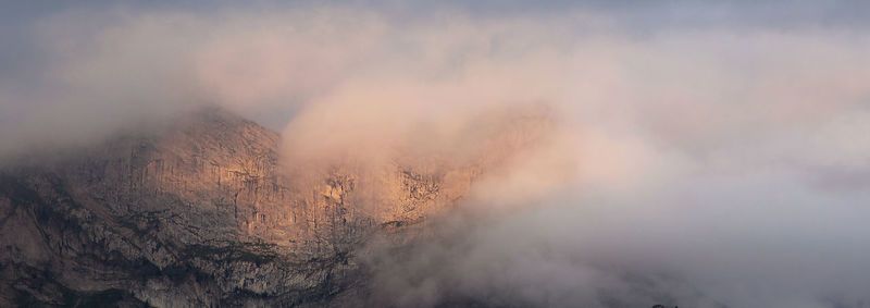 Smoke emitting from mountain against sky