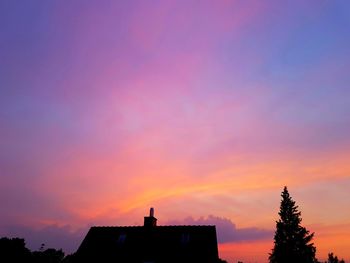 High section of silhouette buildings against sky at sunset