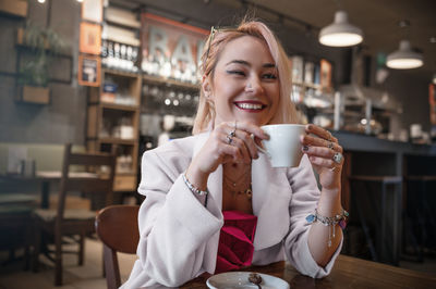 Young woman is drinking coffee in a cafe.