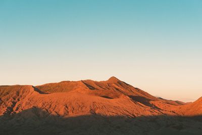 Scenic view of desert against sky during sunset