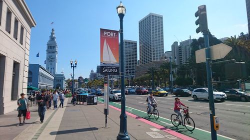 People on city street against sky