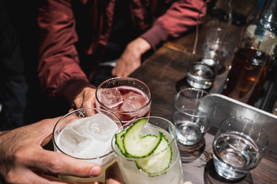 Midsection of man holding wine glasses on table