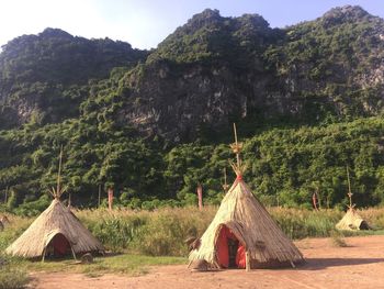 Built structure on land against trees on mountain