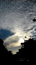 Low angle view of silhouette buildings against sky