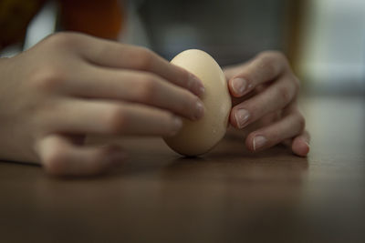 Close-up of kid hand holding egg during beginning of spring