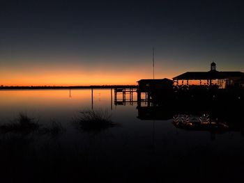 Silhouette boat in sea against sky during sunset