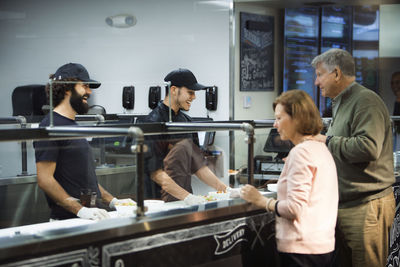 Senior couple ordering food at counter in restaurant