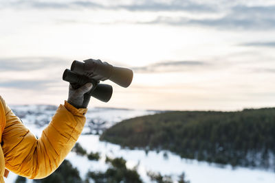 Cropped hand of man holding camera