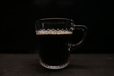 Close-up of a cup of coffee against black background