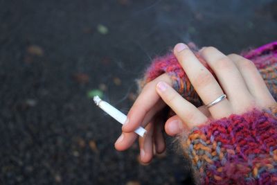 Midsection of woman holding cigarette