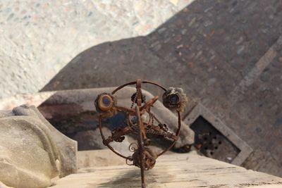 High angle view of rusty candlestick holder hanging on wall