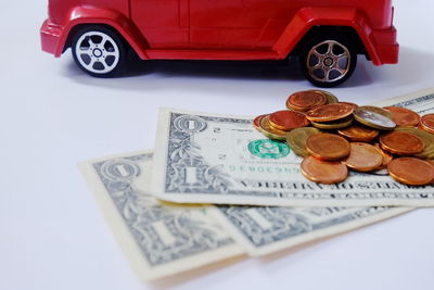 Toy car by currency on white background