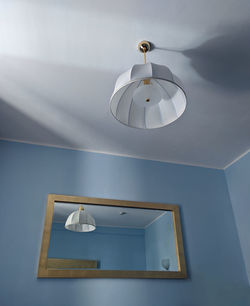 Low angle view of pendant light hanging on ceiling of house