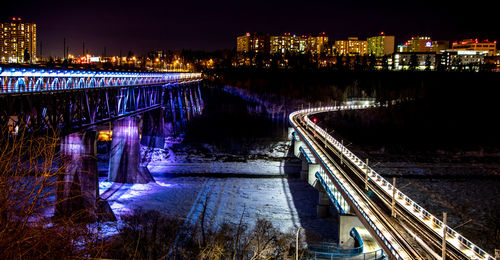 Illuminated cityscape against sky at night