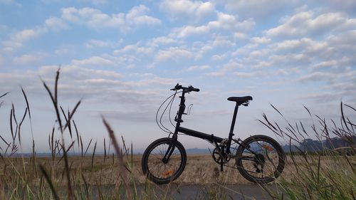 Bicycle on field against sky