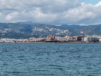 Sea by town against sky