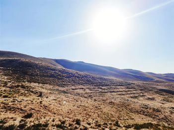 Scenic view of mountains against sky on sunny day