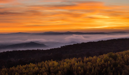 Scenic view of mountains against orange sky