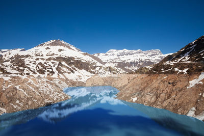 Scenic view of snowcapped mountains against clear blue sky