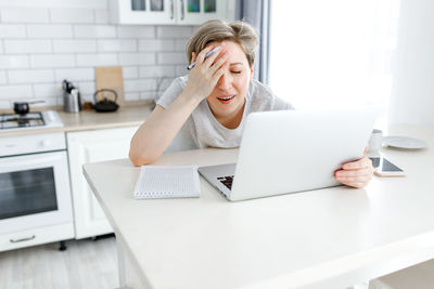 Young woman using mobile phone at home