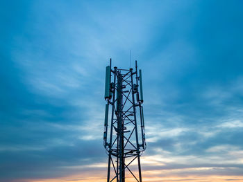 Low angle view of mobile phone base station pylon against sky during sunset