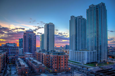 Skyscrapers at fulton river district against sky during sunset