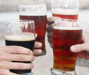 Cropped hands of people toasting beer at bar