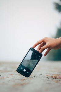 Midsection of person holding mobile phone