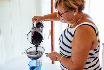 Woman preparing fruit juice at home