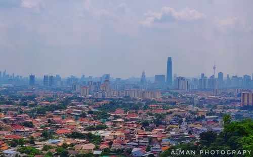 Aerial view of buildings in city against sky