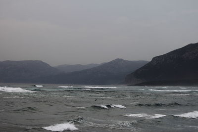 Scenic view of sea and mountains against clear sky