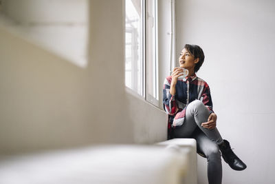 Woman sitting at the window holding cup