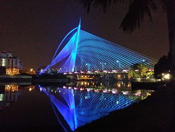 Illuminated city against clear blue sky at night