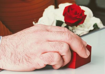 Cropped image of hand holding jewelry box at table